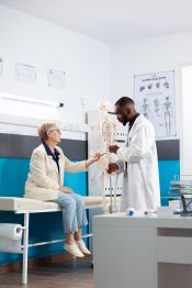 doctor showing skeleton retired woman02