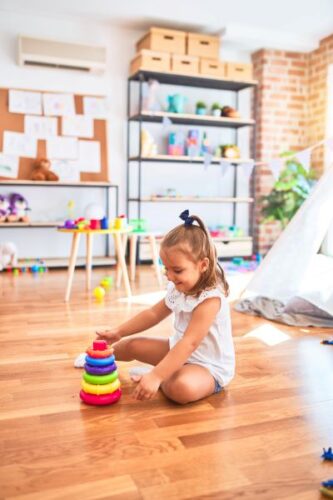 Young beautiful blonde girl kid enjoying play school with toys at kindergarten smiling happy playing with inteligence toys at home
